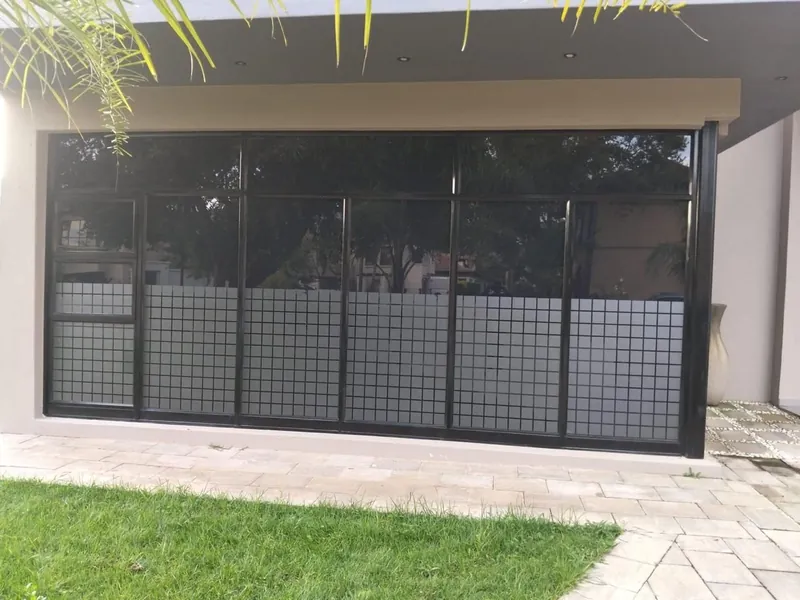 Residential home window in Sandton with custom Nanoshade frosting privacy vinyl on lower panel and solar tint film above